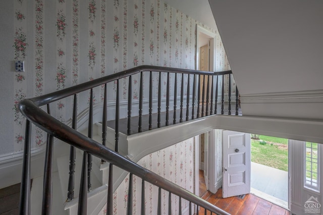 stairs featuring wood-type flooring and wallpapered walls
