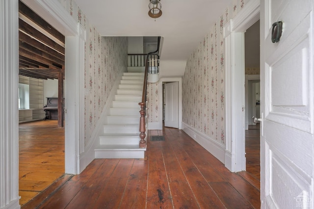 foyer featuring wallpapered walls, hardwood / wood-style flooring, and stairway