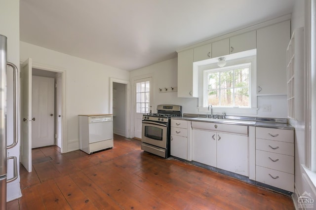 kitchen featuring dark wood finished floors, stainless steel counters, dishwasher, a sink, and stainless steel range with gas cooktop