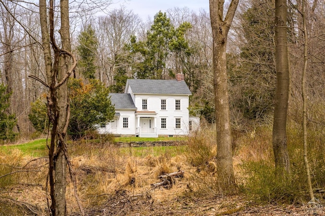 view of front of house featuring a chimney, crawl space, and roof with shingles