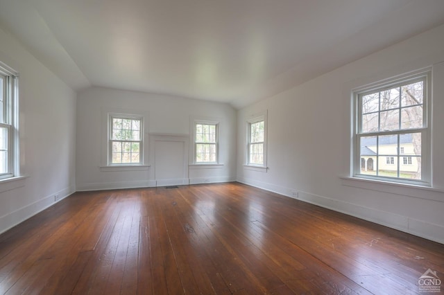 empty room with plenty of natural light, dark wood-style floors, and baseboards