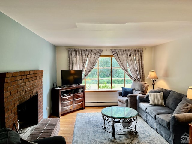 living area with a fireplace, light wood-style floors, and a baseboard heating unit