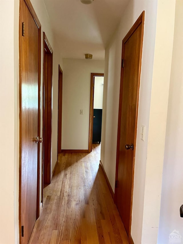 hallway with light wood-style flooring and baseboards