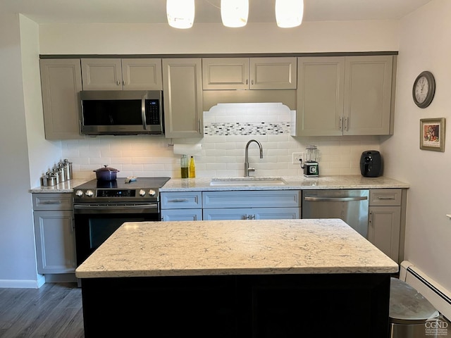 kitchen featuring gray cabinets, a baseboard radiator, appliances with stainless steel finishes, and a sink