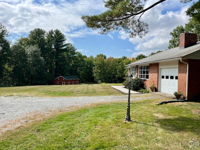 view of yard featuring an attached garage and driveway