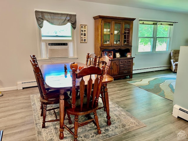 dining room featuring cooling unit, a baseboard radiator, and wood finished floors