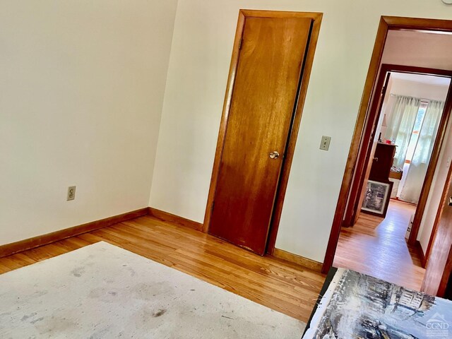 unfurnished bedroom with light wood-type flooring and baseboards