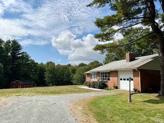 exterior space with an attached garage, a yard, driveway, and brick siding