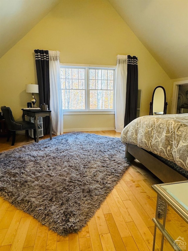 bedroom featuring hardwood / wood-style flooring and lofted ceiling