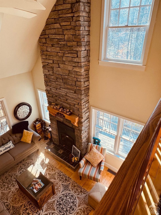 living room with hardwood / wood-style floors, high vaulted ceiling, and a wealth of natural light