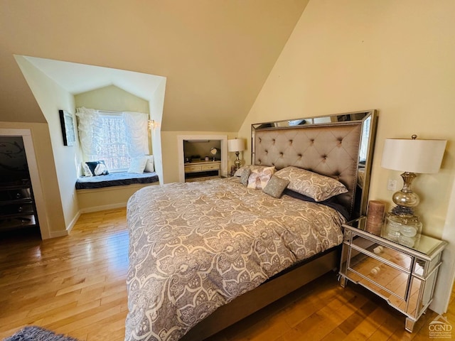 bedroom with hardwood / wood-style flooring and vaulted ceiling