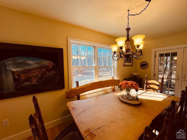 dining space with hardwood / wood-style floors and a notable chandelier