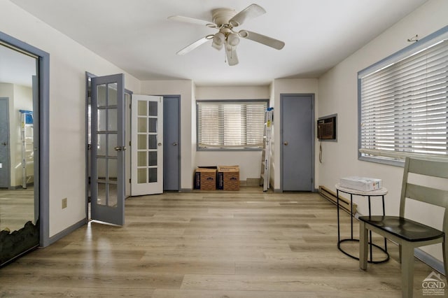 sitting room with an AC wall unit, light hardwood / wood-style flooring, ceiling fan, and a wealth of natural light