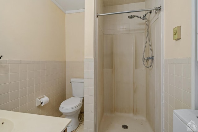 bathroom featuring a tile shower, tile walls, toilet, and vanity