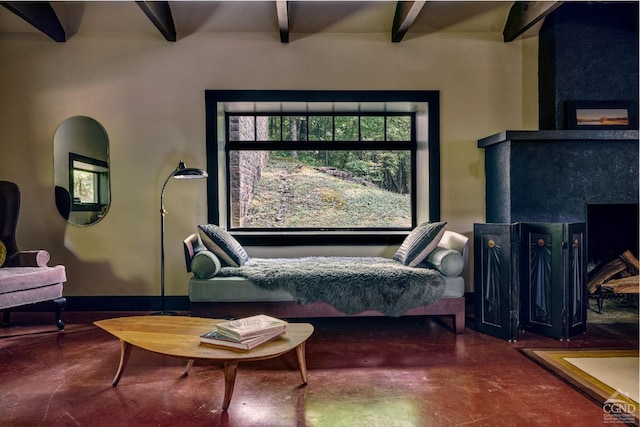 sitting room featuring concrete flooring and beam ceiling