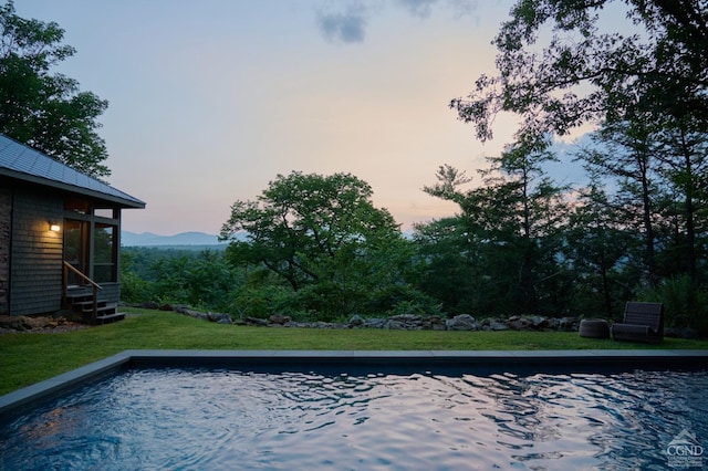 pool at dusk featuring a mountain view