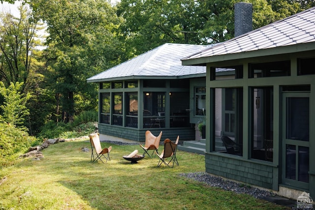 back of property featuring a sunroom and a yard