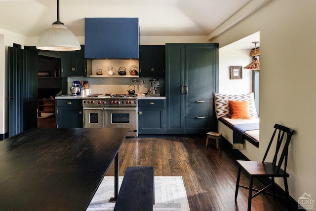 kitchen with pendant lighting, dark wood-type flooring, range with two ovens, blue cabinets, and tasteful backsplash