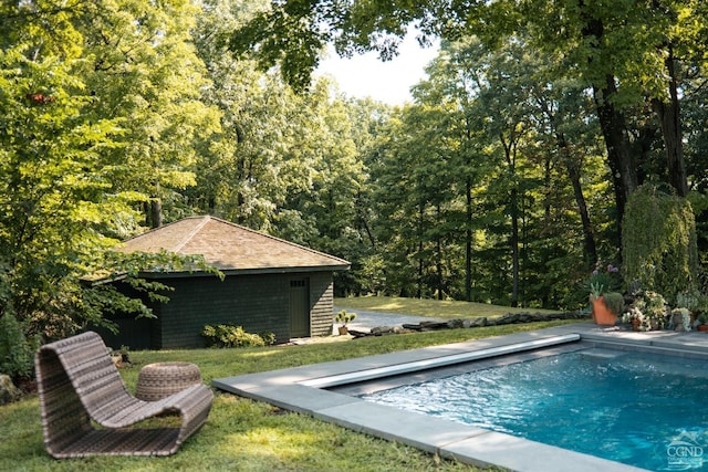 view of pool featuring a lawn and an outdoor structure