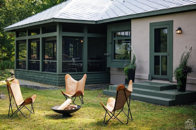 rear view of property with a lawn and a sunroom