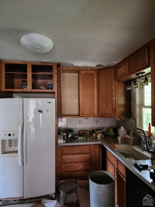 kitchen featuring backsplash, white refrigerator with ice dispenser, and sink