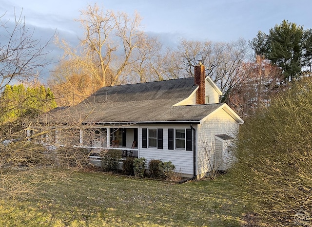 view of side of home featuring a porch and a yard