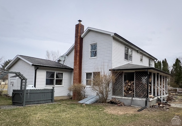 rear view of house featuring a lawn