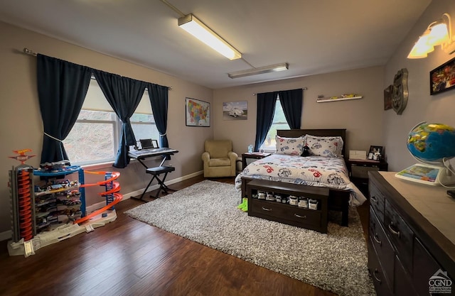 bedroom with dark hardwood / wood-style floors and multiple windows