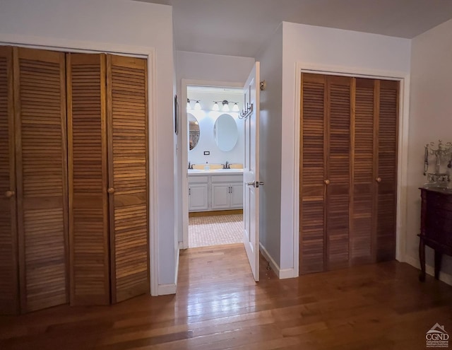 hallway with hardwood / wood-style floors and sink