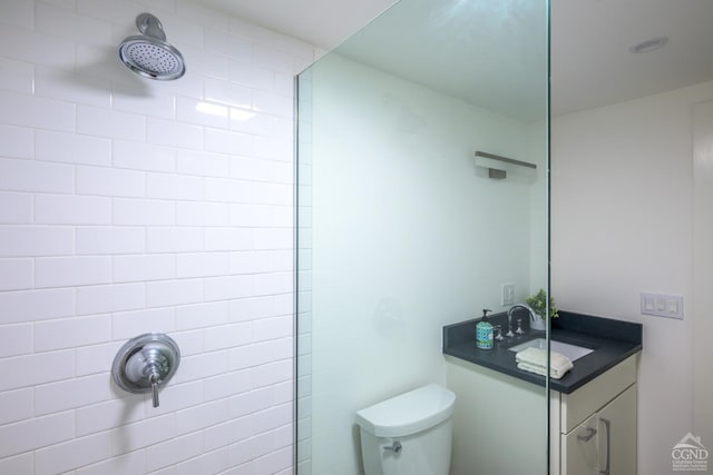 bathroom featuring vanity, toilet, and tiled shower