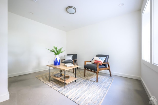 sitting room featuring concrete flooring