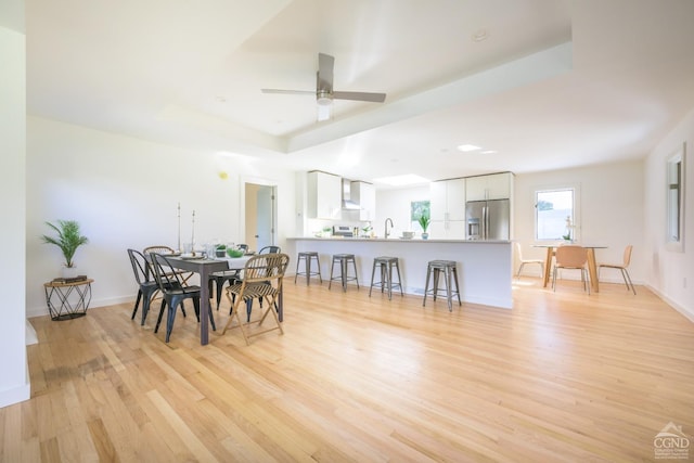 dining room with ceiling fan, light hardwood / wood-style floors, and sink