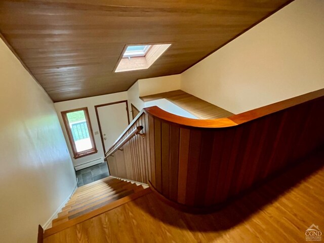 staircase with vaulted ceiling with skylight, wood-type flooring, and wood ceiling