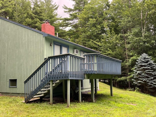 back of house featuring a lawn and a wooden deck