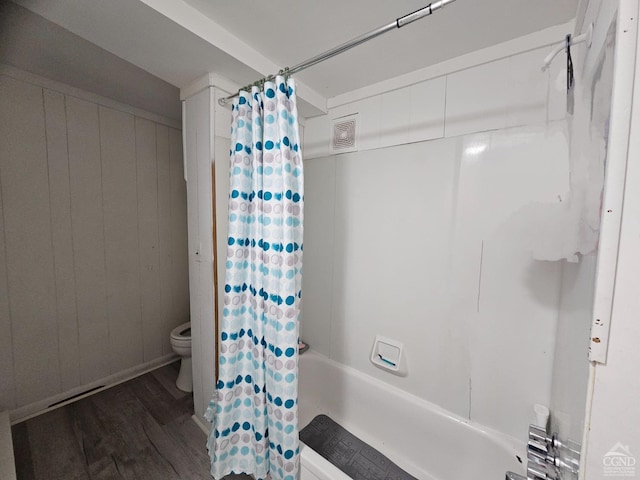 bathroom featuring toilet, shower / bath combo with shower curtain, wood finished floors, and visible vents