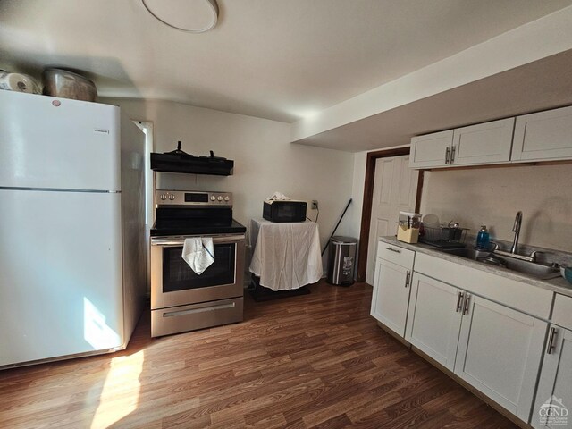 kitchen featuring white cabinets, a sink, dark wood finished floors, electric range, and freestanding refrigerator