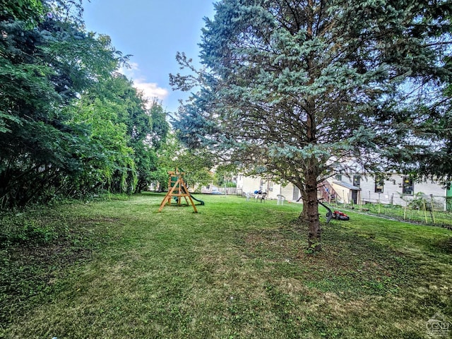 view of yard featuring fence and a playground