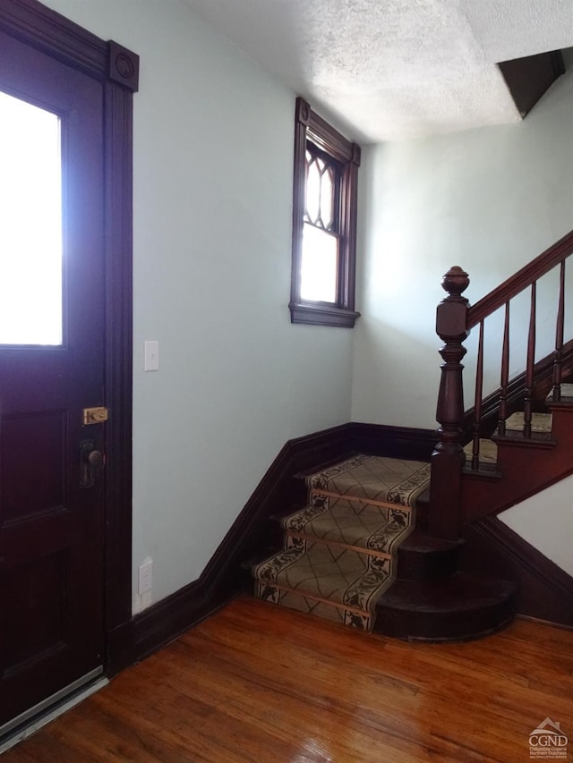 3234 8th St, Hudson, NY 12534 - entrance foyer featuring wood finished floors, stairway, baseboards, and a textured ceiling