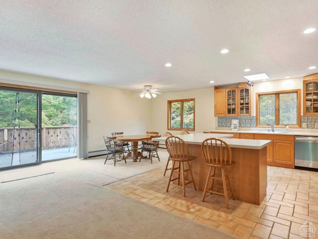 kitchen with dishwasher, a center island, backsplash, light carpet, and a breakfast bar