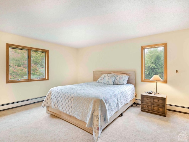 carpeted bedroom featuring baseboard heating and a textured ceiling