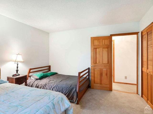 carpeted bedroom featuring a textured ceiling and a closet