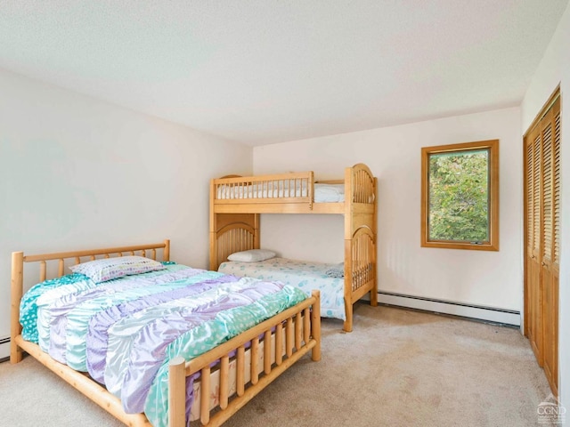 carpeted bedroom featuring a closet, a textured ceiling, and a baseboard heating unit