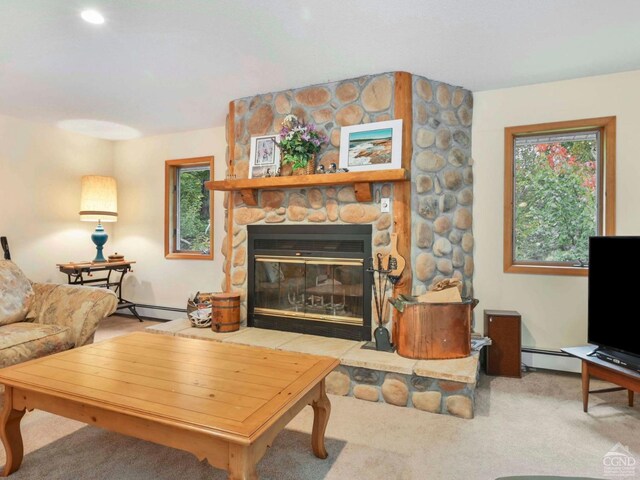 living room with a healthy amount of sunlight, a stone fireplace, carpet floors, and a baseboard radiator