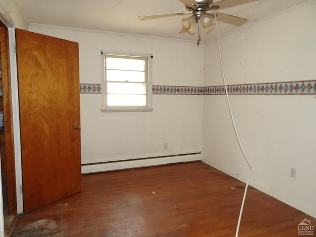 spare room with a ceiling fan, wood finished floors, a baseboard radiator, and crown molding