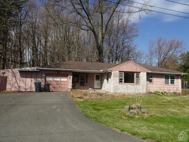 single story home featuring a chimney, aphalt driveway, an attached garage, stone siding, and a front yard