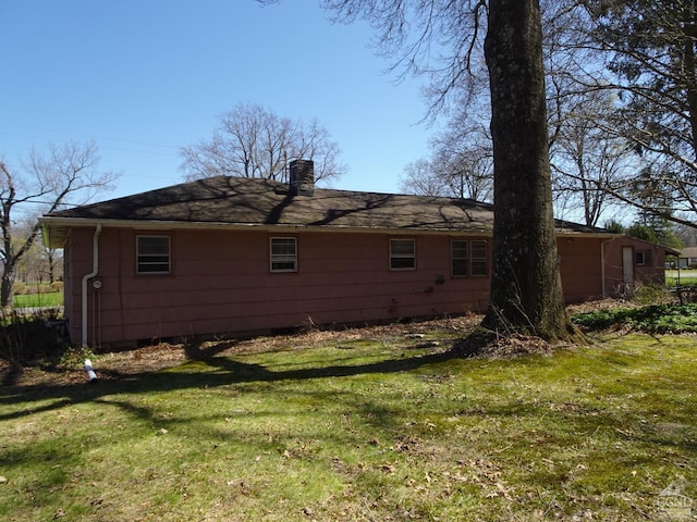 view of property exterior featuring a chimney and a yard