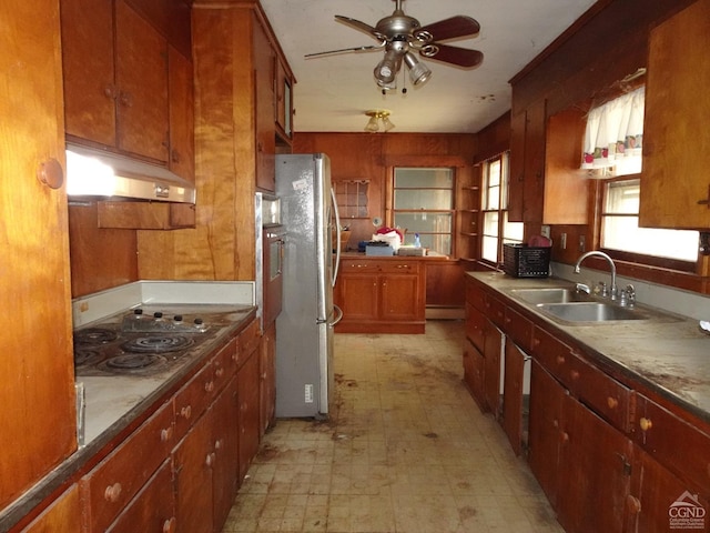 kitchen featuring under cabinet range hood, light floors, a ceiling fan, a sink, and freestanding refrigerator