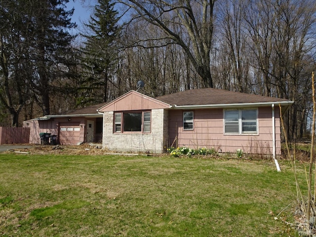 ranch-style home with a garage, a front yard, and fence