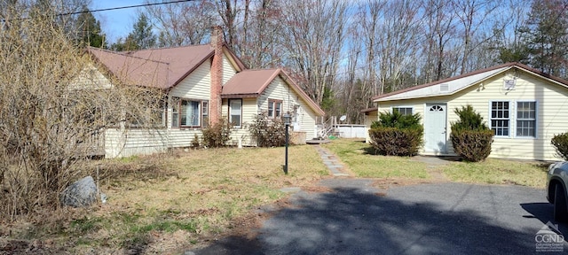 view of property exterior featuring a lawn and a chimney