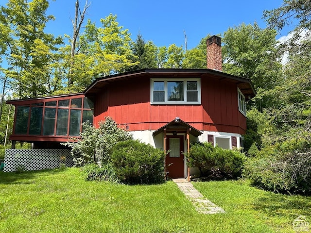 view of front of house with a sunroom and a front yard